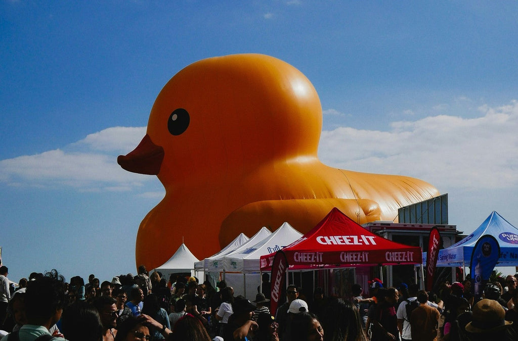 a-large-orange-rubber-duck-floating-over-a-crowd-of-people