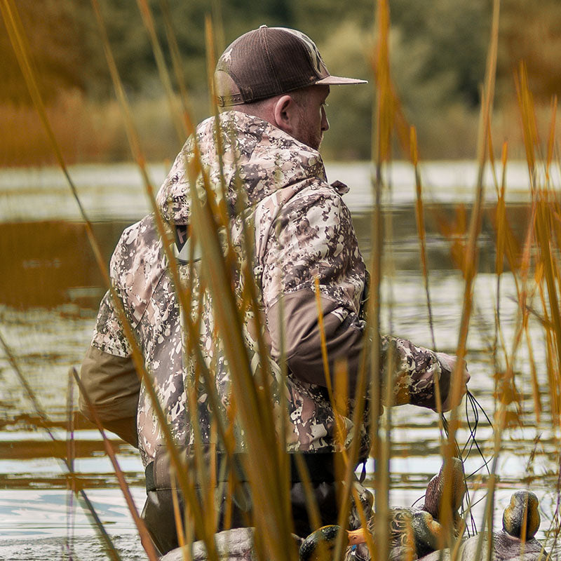 the waterfowl hunter wears TideWe® DeepWade Zip Waders is standing in the water