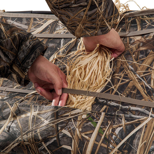 the hunter is using dry grass to hides the Tidewe Panel Blind